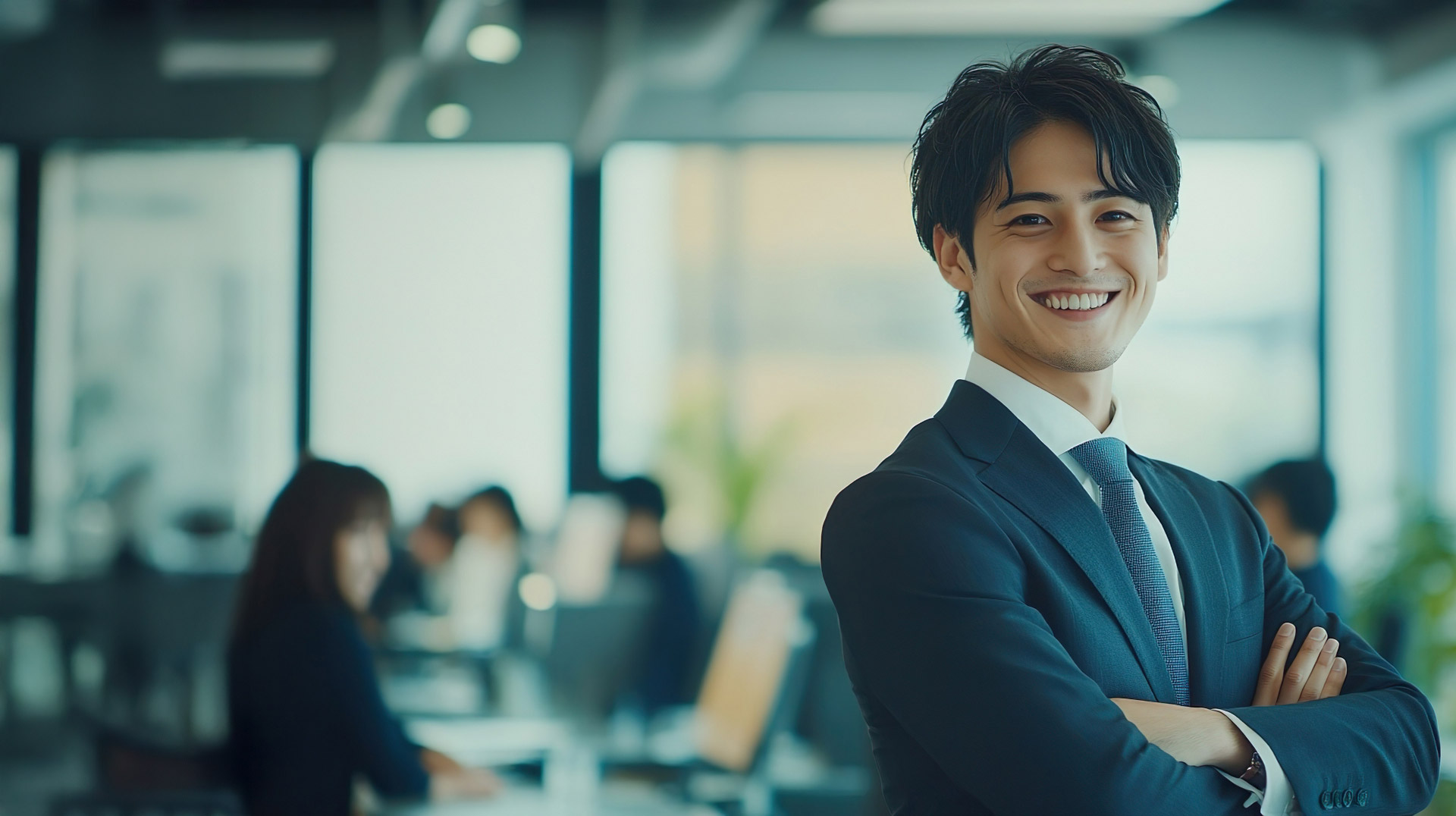 腕を組んでいるスーツ姿の男性